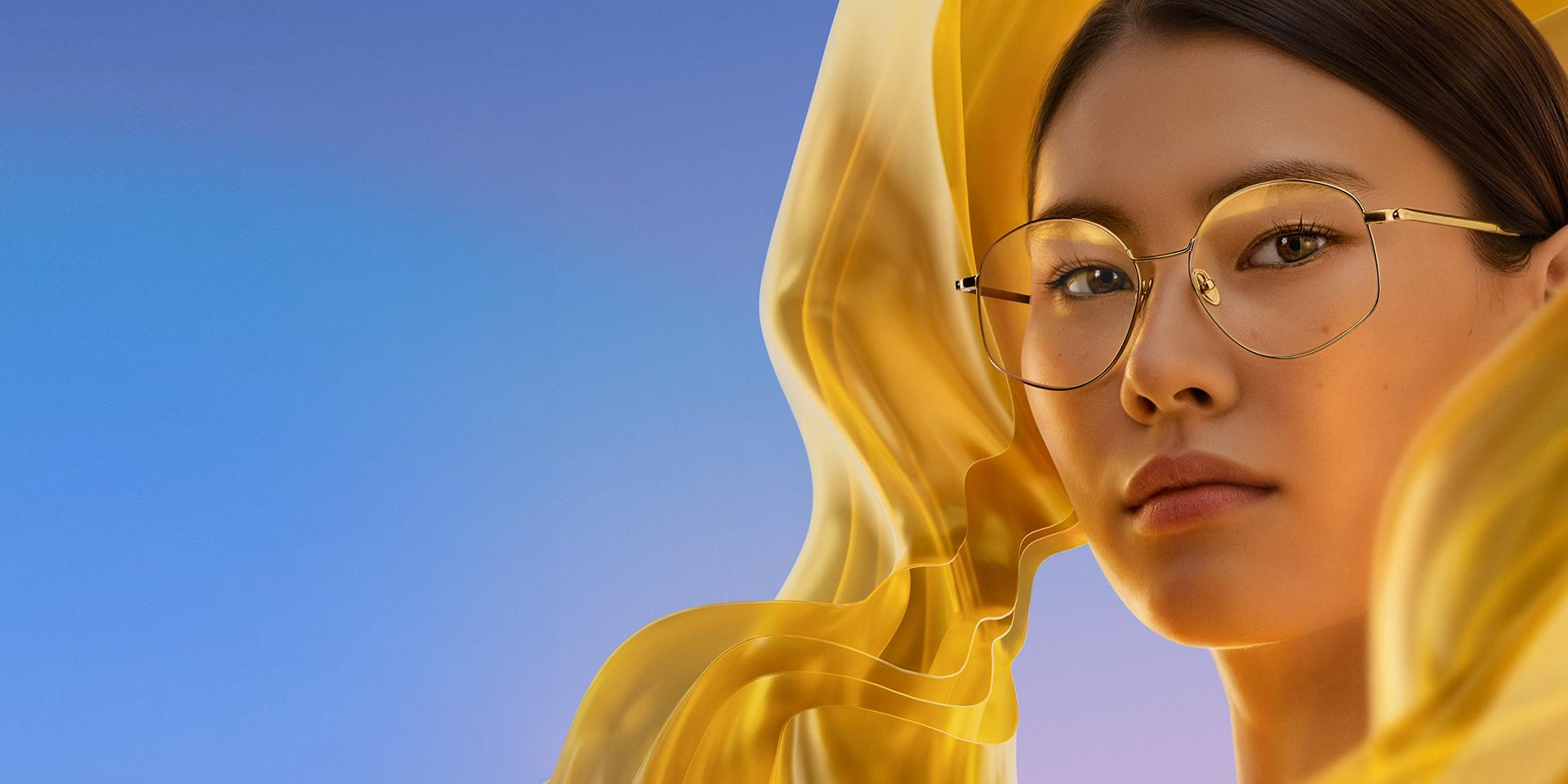 Žena s čírymi okuliarmi ZEISS DuraVision Gold UV, ktoré dodávajú šošovkám jemný, ale výrazný zlatý odlesk.