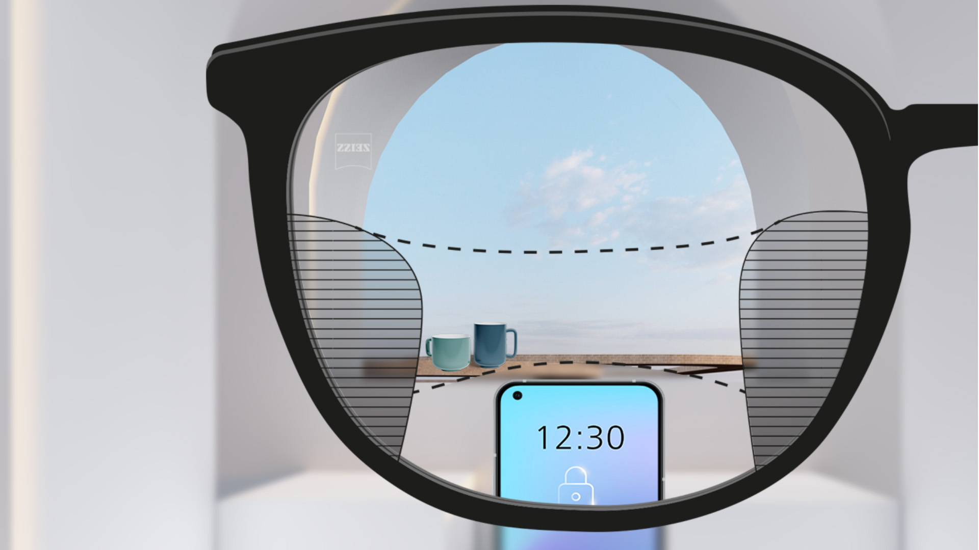Obrázok zorného uhla so šošovkami ZEISS Progressive SmartLife so smartfónom a pohármi v pozadí, zatiaľ čo šošovka je úplne jasná s tenkými rozmazanými políčkami vľavo a vpravo.