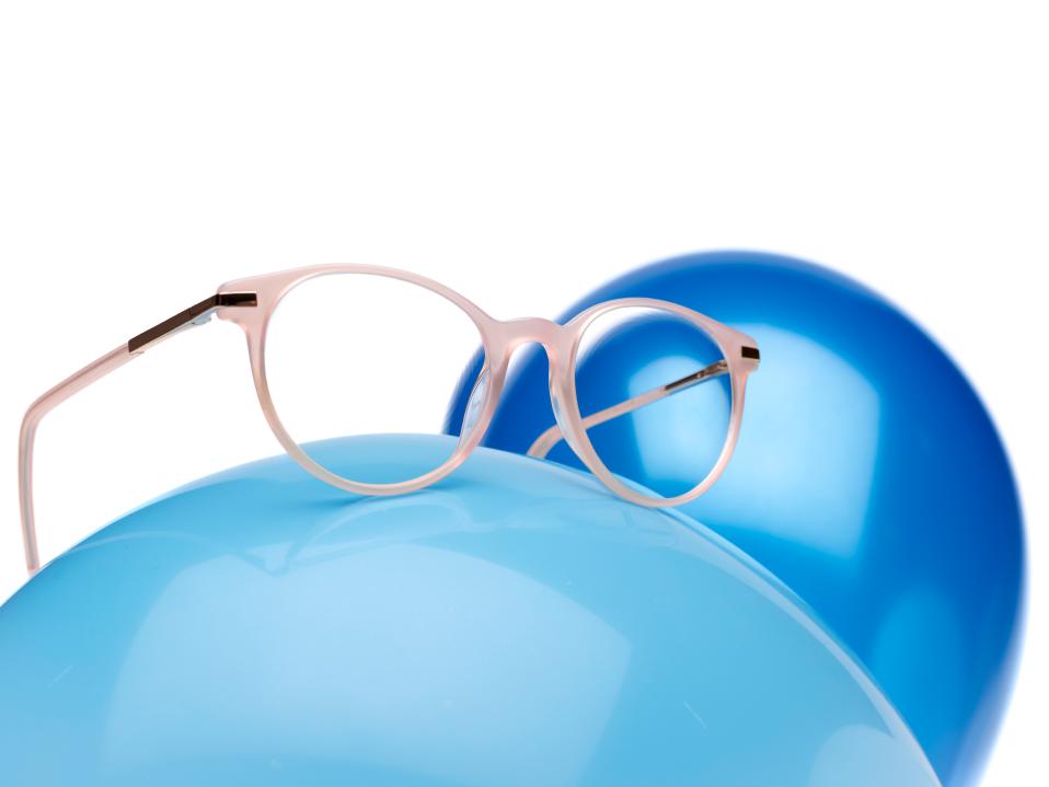 Ružový okuliarový rám so šošovkami ZEISS MyoCare na modrom balóne.