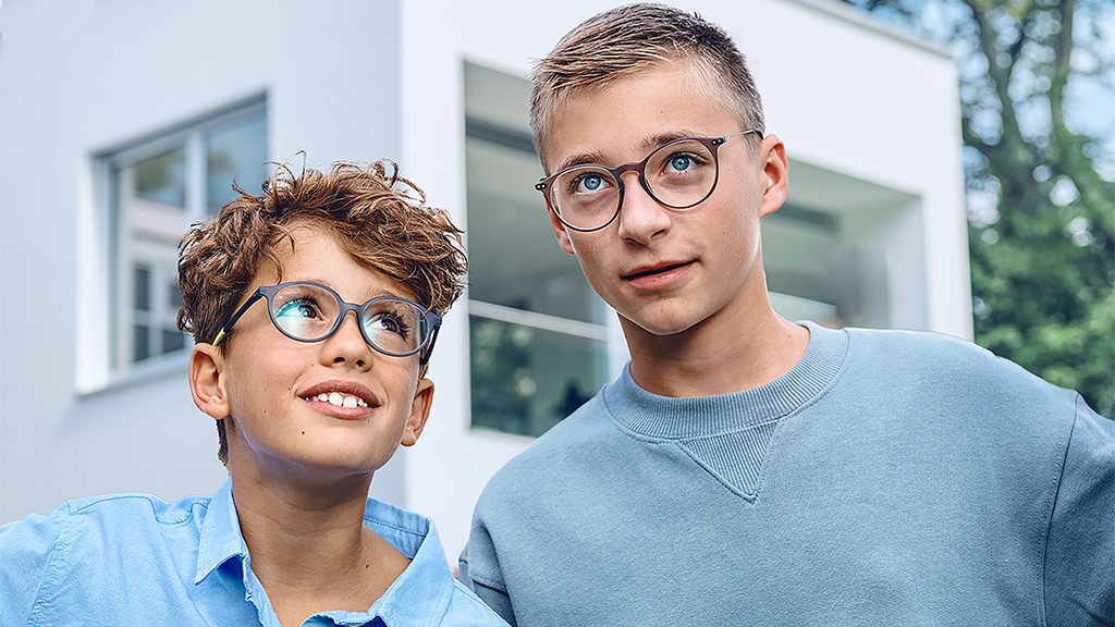 Mladík vzhliadajúci k tínedžerovi, obaja s nasadenými okuliarmi ZEISS Single Vision SmartLife Young